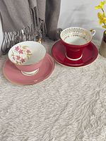 Both teacup and saucer pairs displayed