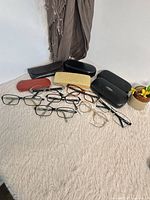 Overview of eight eyeglass frames and six cases on surface