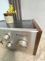 Front left close-up showing model number, knobs, wood side panel