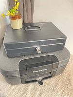 Cash box stacked on fire-resistant chest, shows size and exterior condition