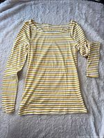 Front view of yellow and white striped long-sleeve Banana Republic shirt laid flat
