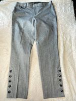 Front view of grey Banana Republic dress pants showing button accents on outer ankles