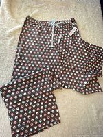Full view of brown coffee cup print pajama pants laid flat