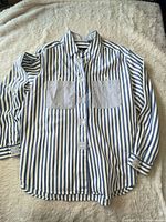 Front view of striped shirt showing pockets, buttons, collar