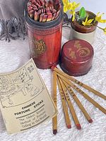 Canister with lid open showing sticks, booklet, several sample sticks displayed