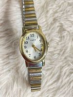 Front view of Timex watch showing oval case, dial, hands and stretch band