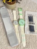 Group showing both watches, clear case, sealed strap