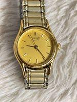 Front view showing gold-tone dial, case and Seiko Quartz branding