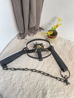Full view of wrought iron foot trap clock with chain