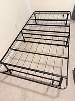 Bed frame fully opened showing metal slat platform and legs