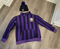 Full view of sweatshirt and beanie laid flat