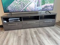 Front view of TV stand showing three cubbies and three drawers