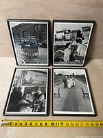 Group shot of four framed photographs with tape measure for scale