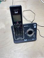 Front view of handset docked in base showing brand logo, screen, keypad and base controls