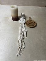 Candle, rope hanging, and trivet grouped