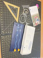 All items laid out: decorative trimmer, star stencil, letter aligner template, tearing rulers and box