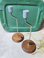 Front view of both lamps showing offset stands, wood bases, gray sockets, cords