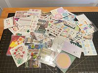 Wide view of assorted sticker sheets spread on cutting mat