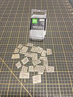 Metal alphabet charms set with loose pieces displayed