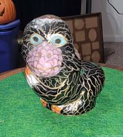 Front view of cloisonné ape figurine showing facial details and colour scheme