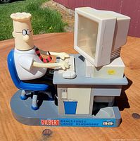 Front view of Dilbert candy dispenser showing figure at desk and branding