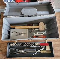 Toolbox open showing assorted tools in upper tray and lower compartment