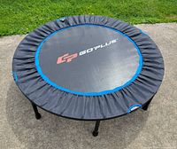 Top view of round Goplus trampoline showing logo, blue trim, assembled legs