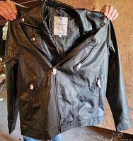 Front view of jacket on hanger showing overall design and pocket zippers