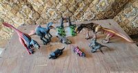 Overall lot with all dinosaur figures, gate playset and jeep on table