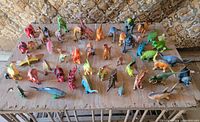 Full overhead view of entire assortment of plastic dinosaur figures on wooden surface