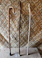 three wooden walking sticks upright showing overall appearance and rubber tips