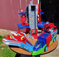 All three Paw Patrol pieces on table: lookout tower, truck body, jet section