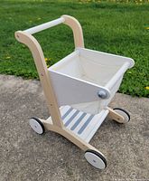 Entire cart side perspective showing wood frame, handle, wheels, basket and lower shelf
