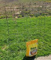 Front view showing sealed Preen bag with three metal tomato cages behind
