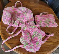 Overview of all three matching Vera Bradley quilted floral bags on table