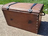 Wooden chest front and side view showing iron lid straps and nail heads