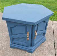 Front view of blue hexagon wooden side table with closed doors