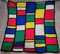 Full view of crocheted afghan showing overall geometric block design