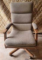 Front view showing full chair, upholstery, wood frame and casters