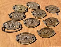 all ten brass drawer pulls arranged face up