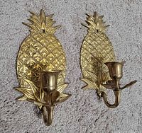 Front view of both brass pineapple sconces showing design and candle cups