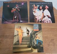 Overview of all three album covers laid on wooden surface