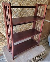 Front view of dark wood 3-tier folding shelf standing upright