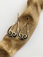 Front view of both earrings on wood prop