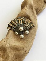 Front view of silver fan brooch with five pearls