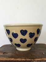 side view of beige stoneware bowl with blue heart pattern