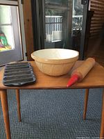 All three items on table: ceramic bowl, cast iron pan, rolling pin