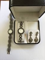 Set showing two watches and earrings in box