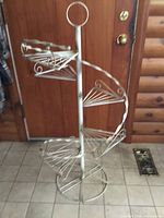 Full view of metal spiral plant stand showing shelves and ring top