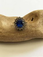 Front view of ring showing blue center stone and clear halo